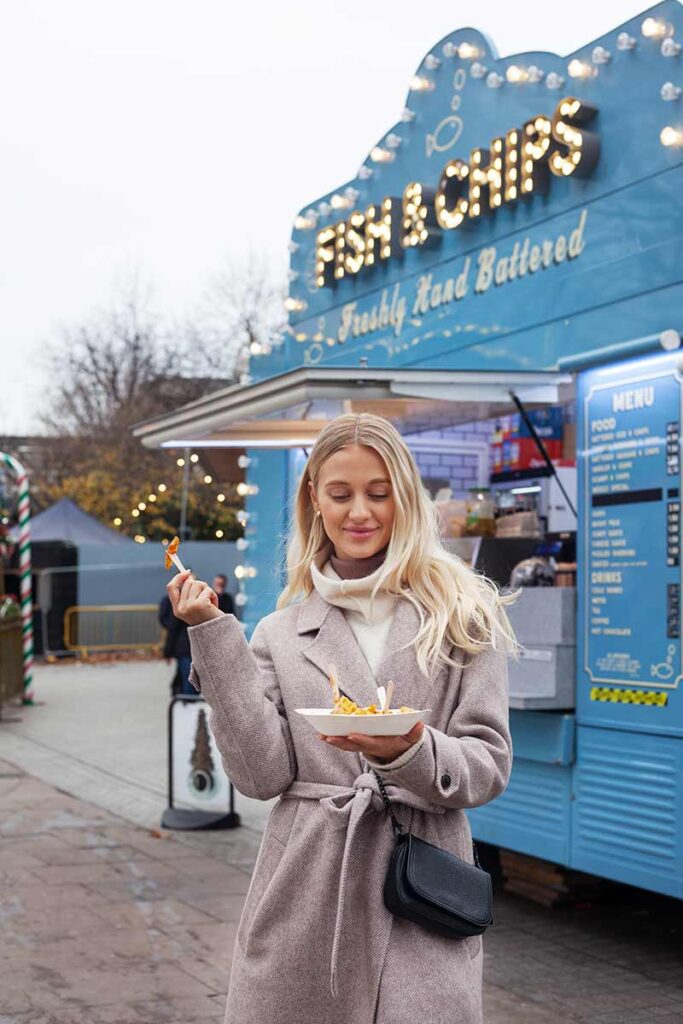 London Food: London street food, fish and chips cart at the back and a woman street food shopping