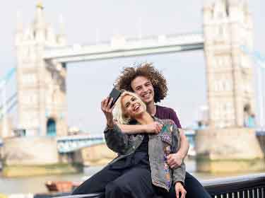 Couple taking a selfie with Tower Bridge on the background, London